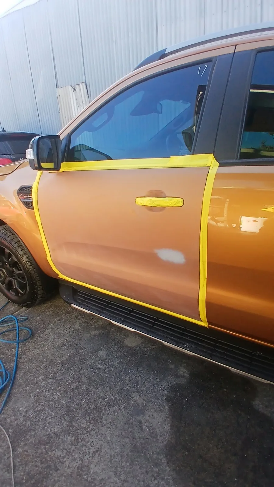 Gold ute door masked and prepared for paint repair