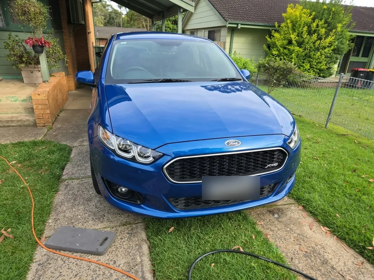 Blue Ford with clear headlights after restoration, number plate obscured