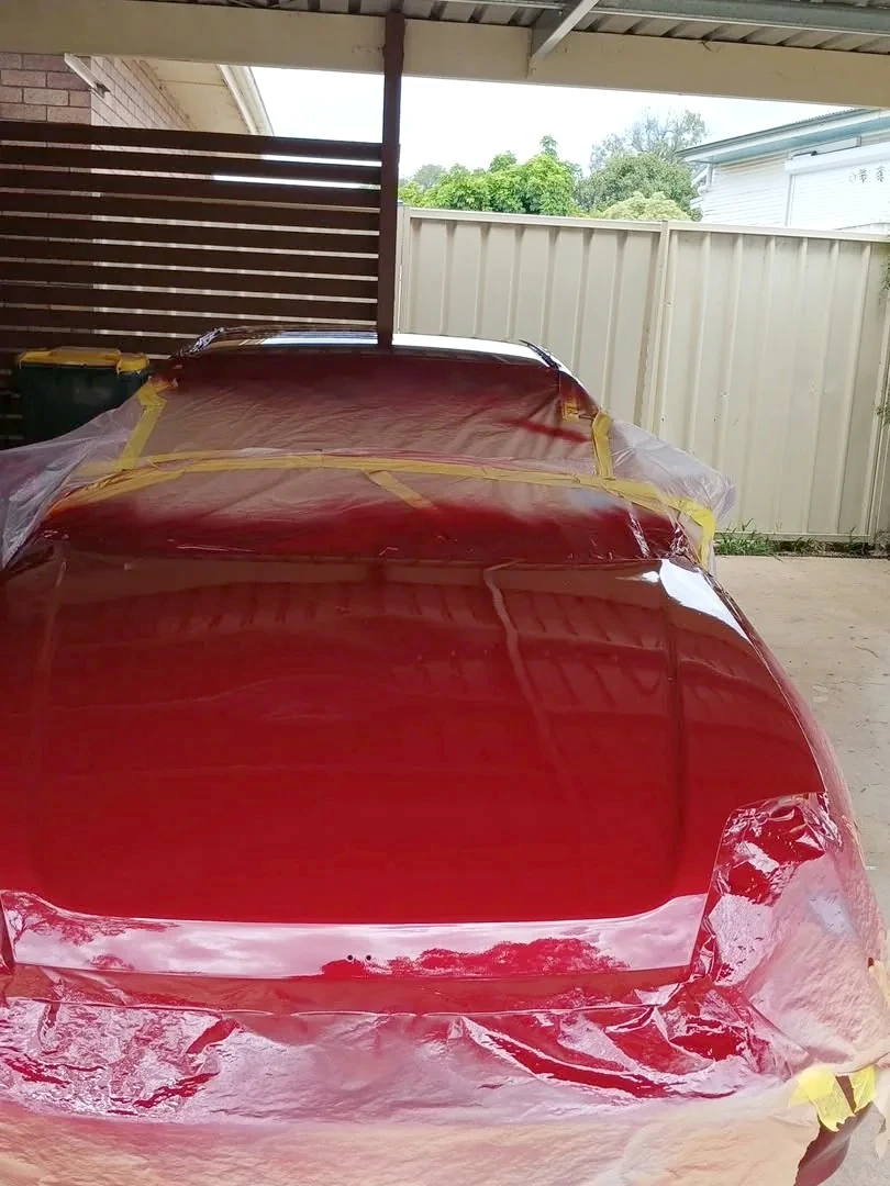 Red Honda with fresh red paint finish during refinishing